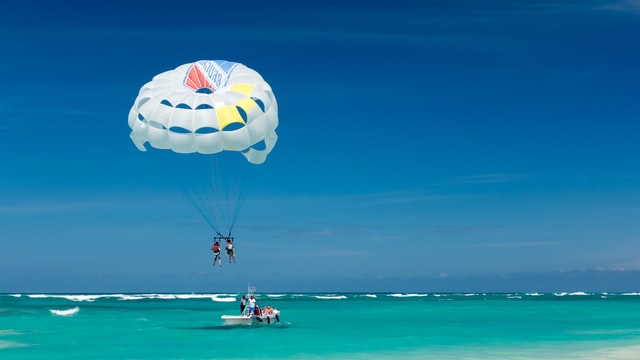 A person in parachuting which is one of the things you have to do when you are in Cancun